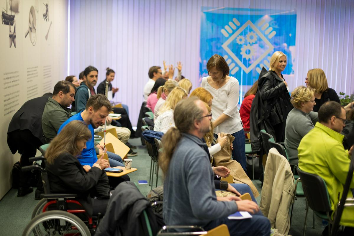 Na fotografiji so udeleženci Konference o digitalni dostopnosti. Fotografirani so v predavalnici. Med njimi je tudi ženska, ki sedi na invalidskem vozičku. Foto: Matej Pušnik