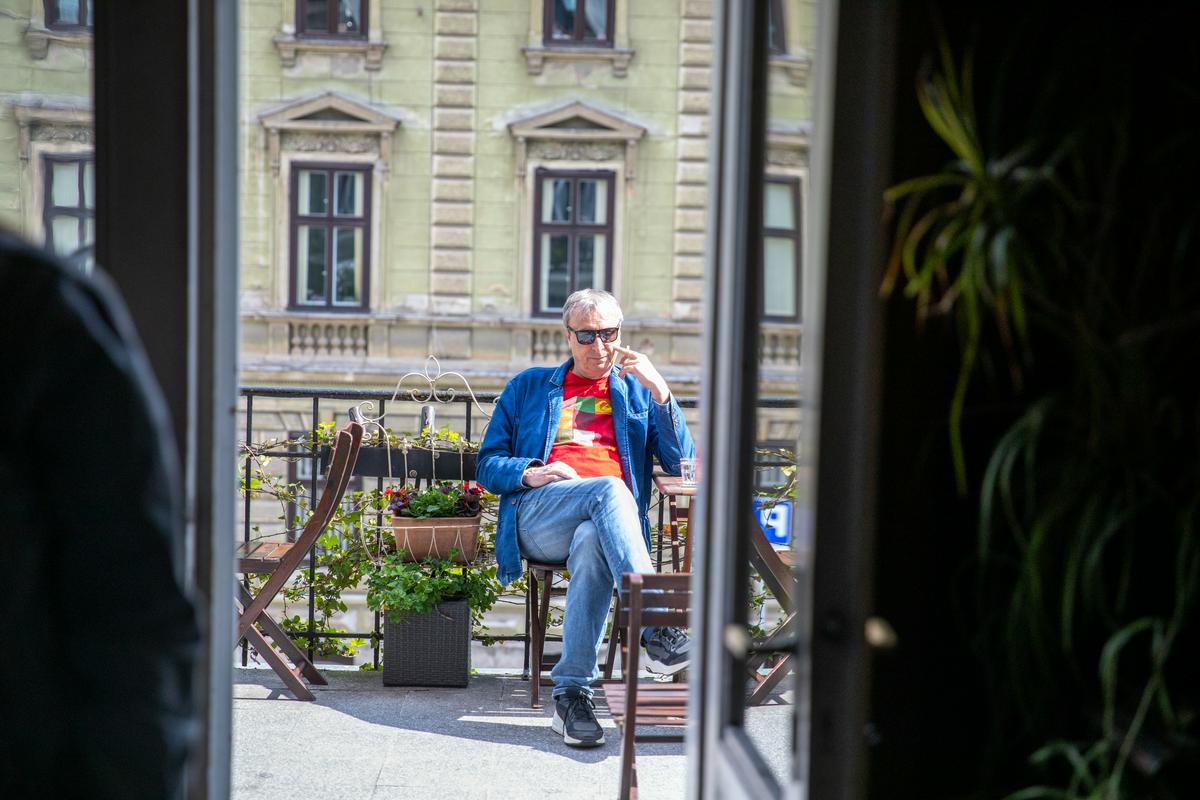 Režiser Matjaž Zupančič sedi na balkončku kavarne v SNG Drama. Foto: Adrijan Pregelj/ RTV SLO