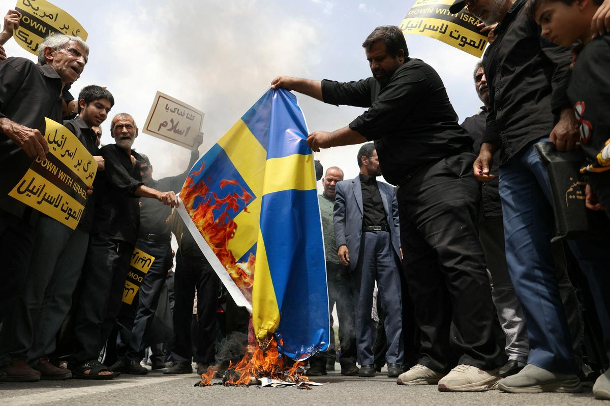 V Teheranu so iranski protestniki zažigali švedske zastave. Foto: Reuters