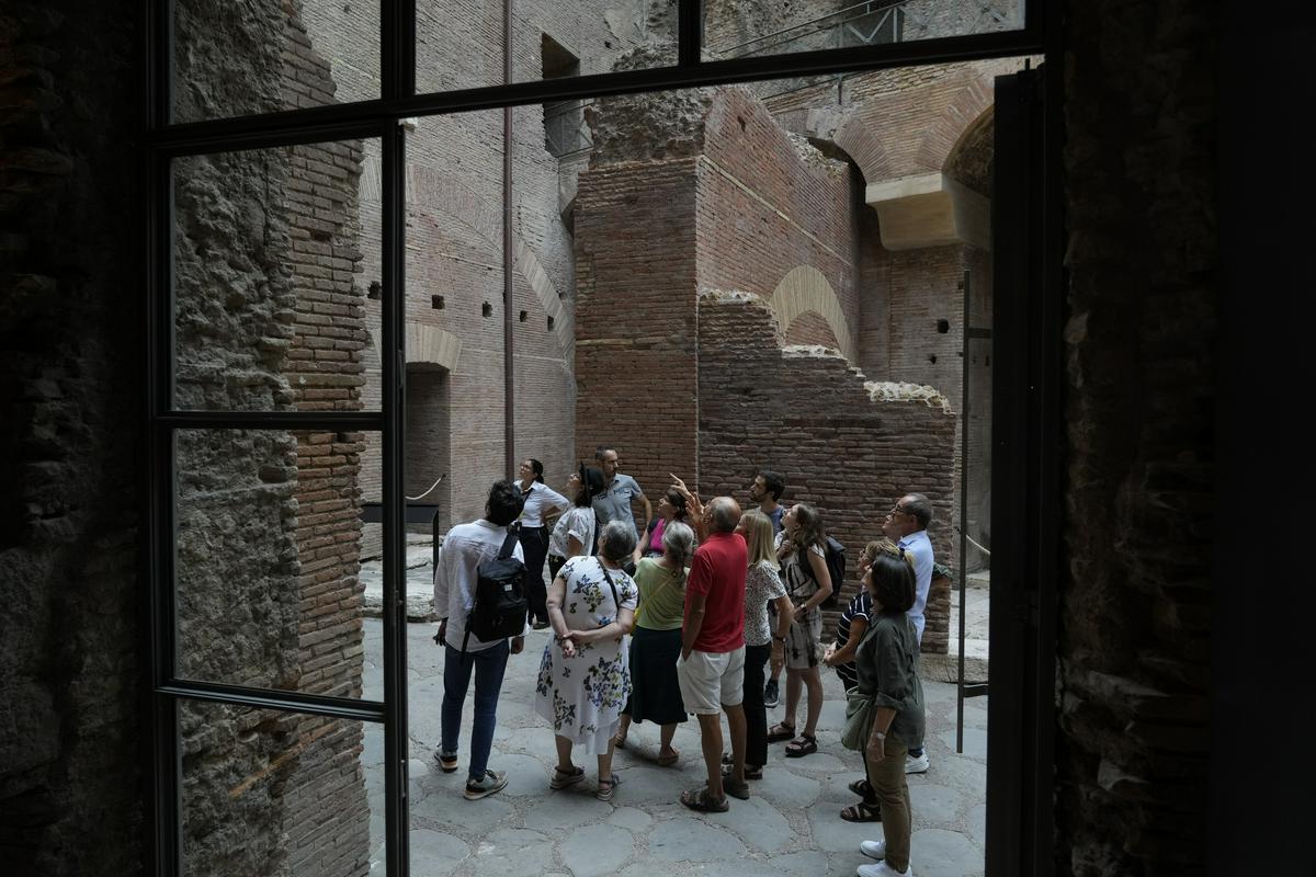Obiskovalci v notranjosti Tiberijeve hiše: prizor, ki ga je mogoče znova videti po skoraj polstoletni obnovi te rimske znamenitosti. Foto: AP