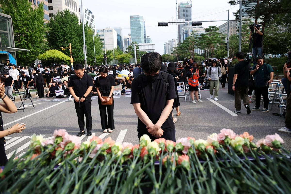 Na protestih so se učitelji poklonili umrlim kolegom. Foto: Reuters