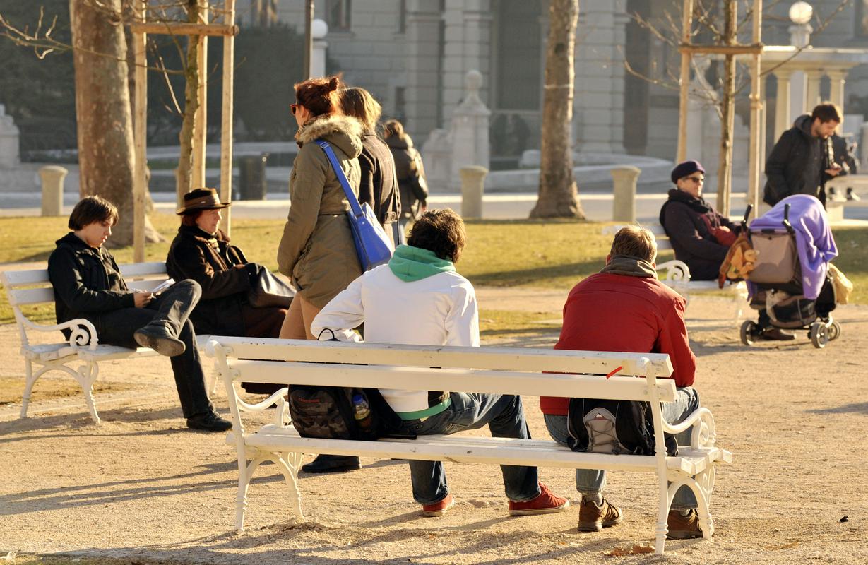 Ljudje sedijo na klopeh. So obsijani s soncem. Foto: BoBo