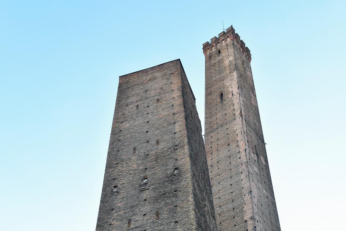 Slavna srednjeveška stolpa v Bologni. Nevarno se nagiba nižji, imenovan Garisenda, ki je visok slabih 50 metrov. Foto: Reuters