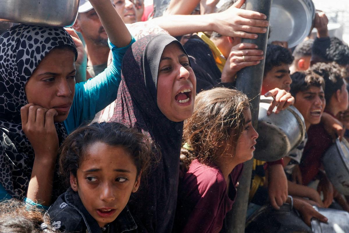 Palestinci čakajo v vrsti za hrano pred javno kuhinjo. Foto: Reuters Palestinci čakajo v vrsti za hrano pred javno kuhinjo. Foto: Reuters