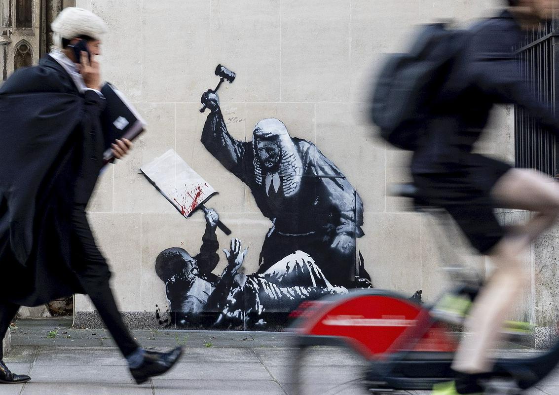 Banksy na pročelje sodišča naslikal sodnika, ki s kladivcem udriha po neoboroženem protestniku