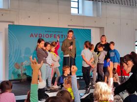 Ajda Smrekar in otroci iz OŠ Poljane na Avdiofestivalu 2025. Foto: Tanja Mojzer