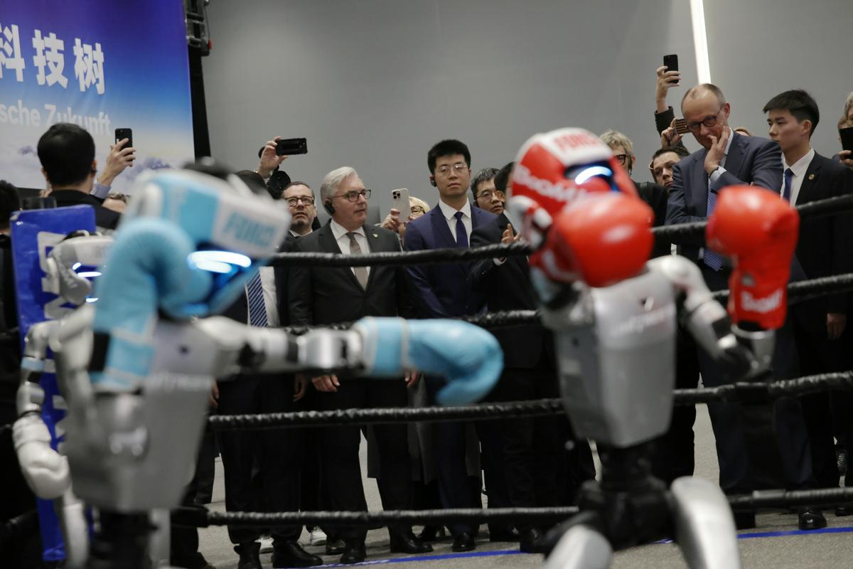 Nemškega kanclerja na Kitajskem zabaval tudi boksarski dvoboj robotov