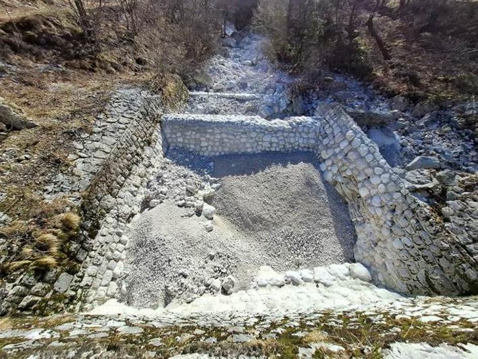 Pri izviru Tolminke obnavljajo poškodovano zaplavno pregrado